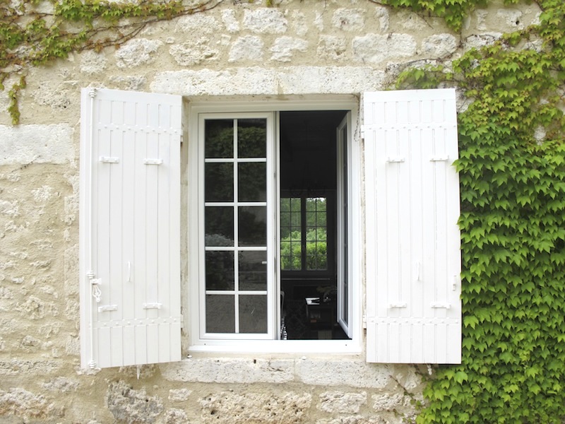 White wooden shutters set into the stone walls